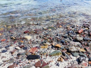 The water's edge with beach stones and sand
