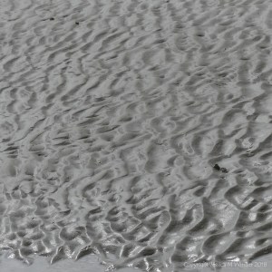 Natural pattern and texture in wet beach sand