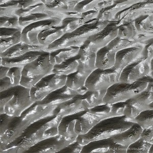Close-up of natural ripple patterns in wet sand