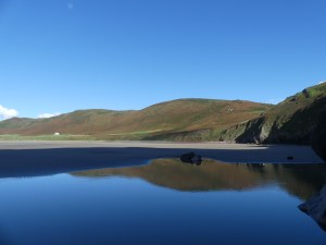 Reflection of Rhossili Down in tide pool on the beach