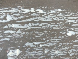 Natural patterns of sea foam on the beach