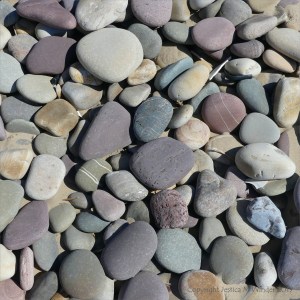 Pastel coloured dry pebbles on the beach