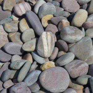 Pastel coloured dry pebbles on the beach