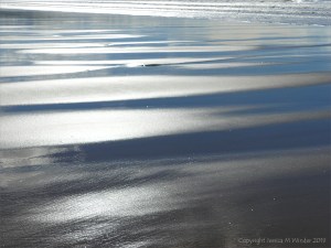 Wet sand gleaming in sunlight