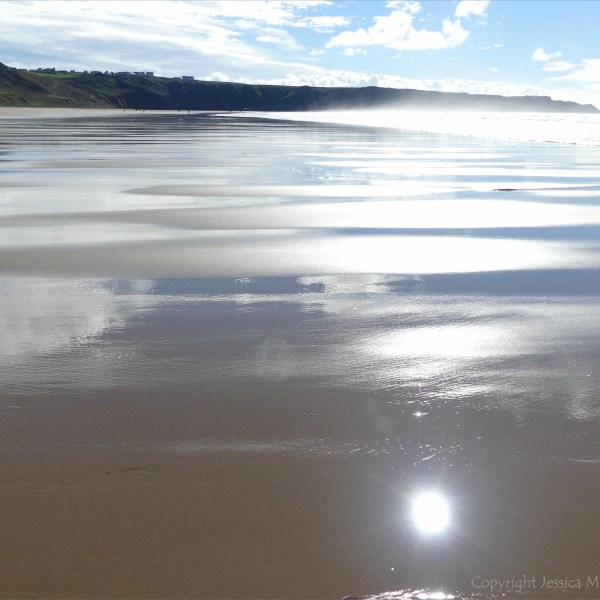 Wet sand gleaming in sunlight