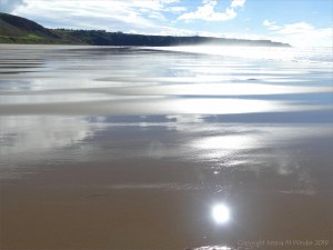 Wet sand gleaming in sunlight
