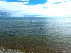 Natural patterns of reflected light on the surface of calm sea water - context shot