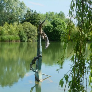 "The Chase" bronze sculpture in a lake