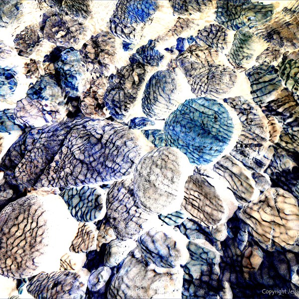 Natural patterns of reflected light on river-bed pebbles