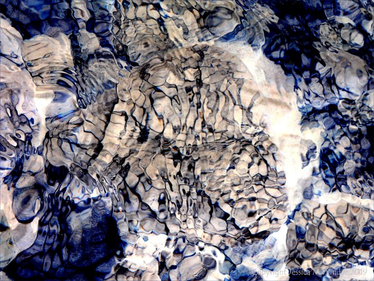 Natural patterns of reflected light on river-bed pebbles