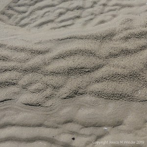 Natural sand patterns left by the ebbing tide