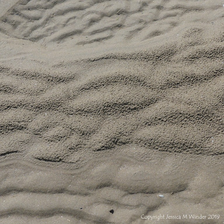 Natural sand patterns left by the ebbing tide