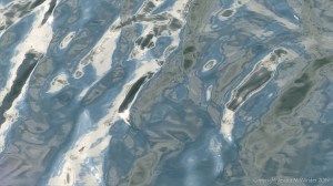 Rippled water reflecting clouds and sky