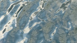 Rippled water reflecting clouds and sky