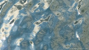 Rippled water reflecting clouds and sky