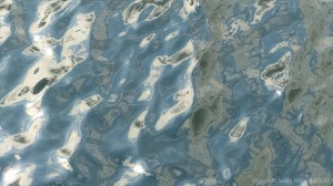 Rippled water reflecting clouds and sky