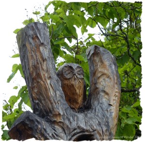 Carved owl against the tree top
