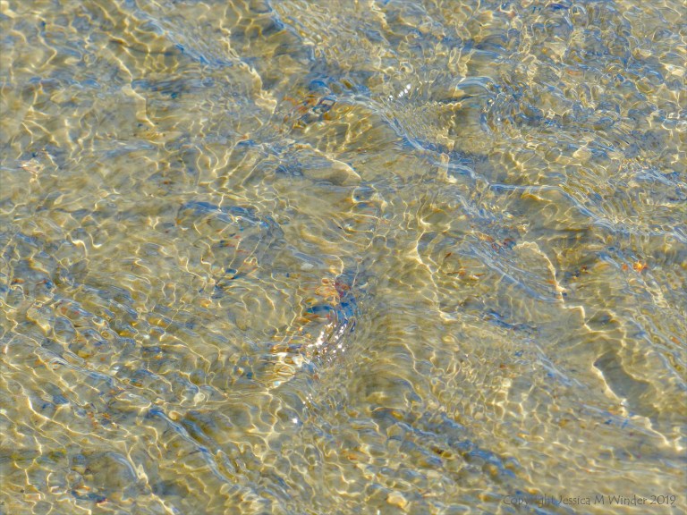 Ripple patterns on shallow water over sand