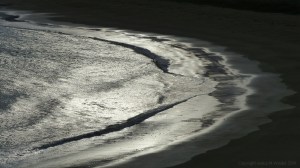 Beachscape with reflected dawn light on the sea