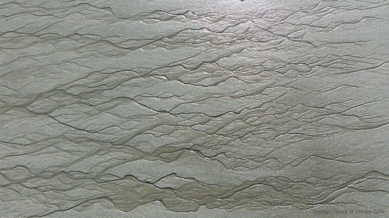 Natural patterns in the sand on a beach as the tide goes out