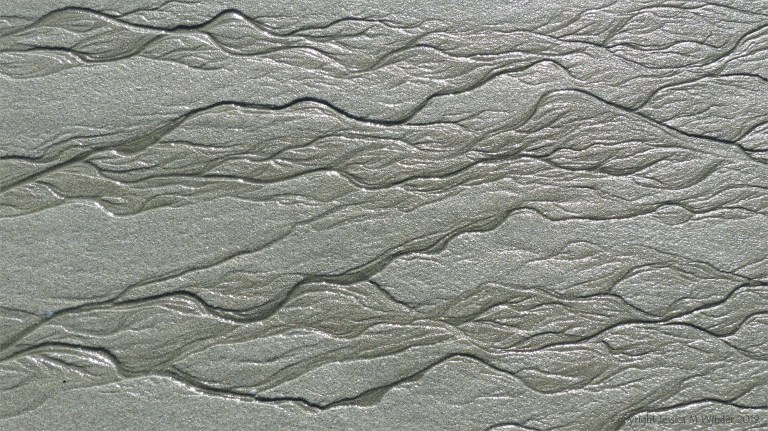 Natural patterns in the sand on a beach as the tide goes out