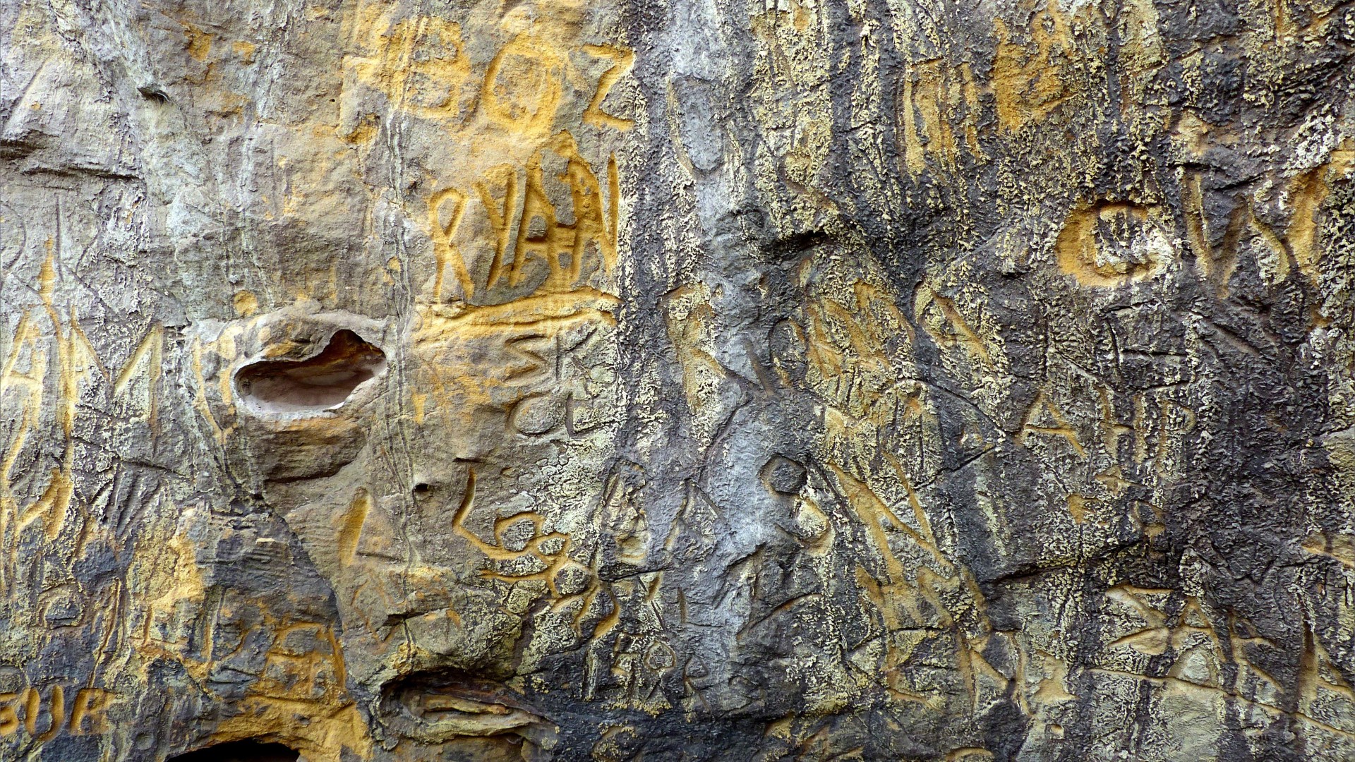 Graffiti carved into natural rock face