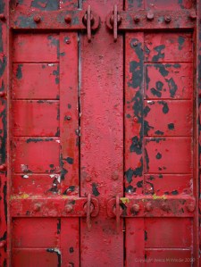 Flaking red paint on a piece of wooden agricultural equipment