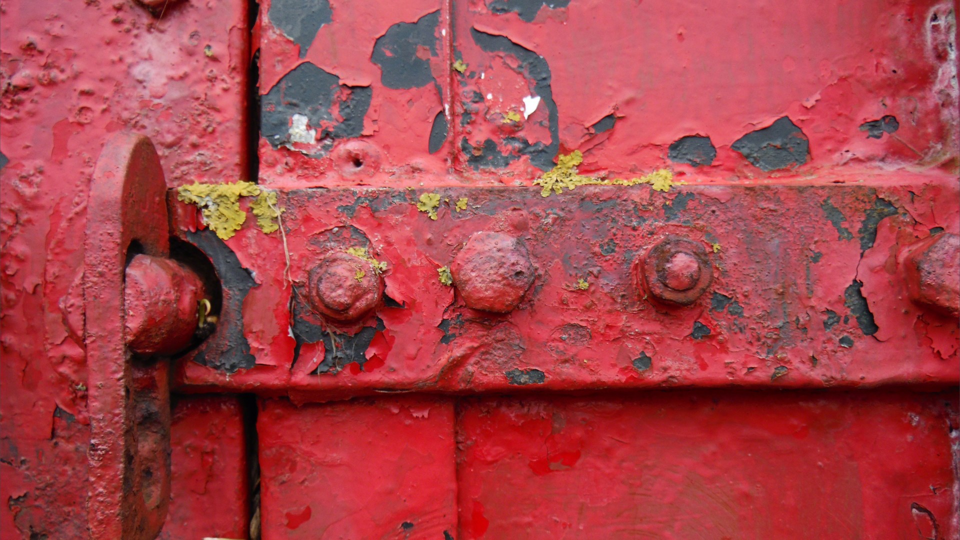 Flaking red paint on a piece of wooden agricultural equipment