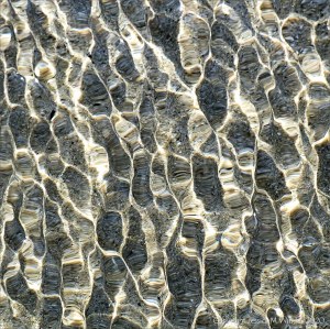 Refracted light on shallow tide pool rippled water