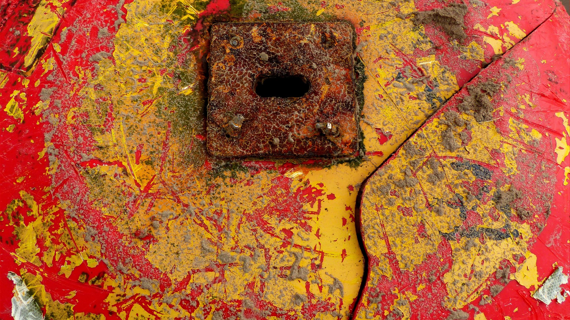 Close-up detail of red buoy washed up on sandy beach as flotsam