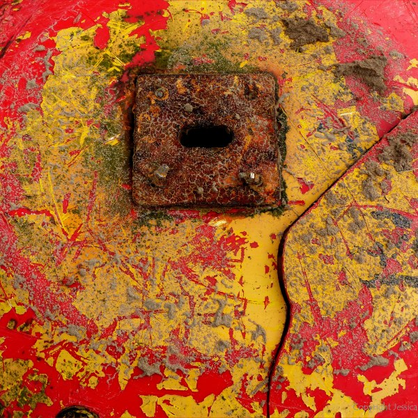 Close-up detail of red buoy washed up on sandy beach as flotsam