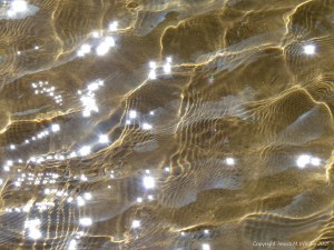 Reflected light on the surface of a stream with sparkles