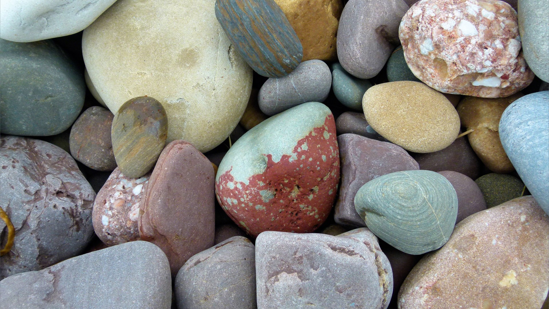 Large pebbles of different rock types on the beach