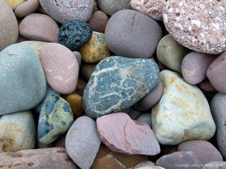 Large pebbles of different rock types on the beach