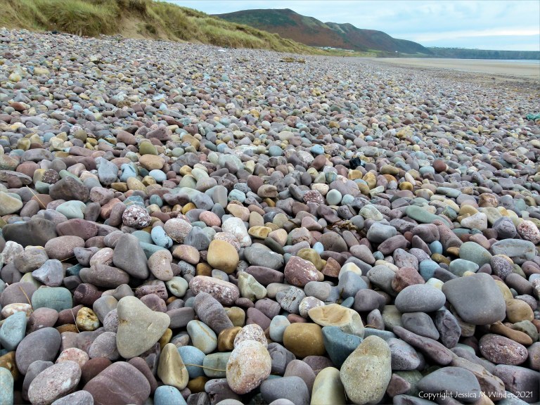 Large pebbles of different rock types on the beach