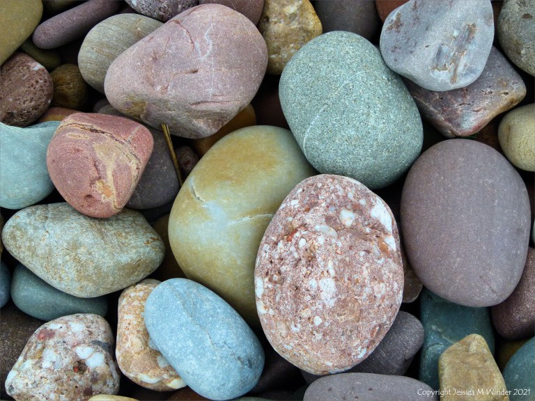 Large pebbles of different rock types on the beach