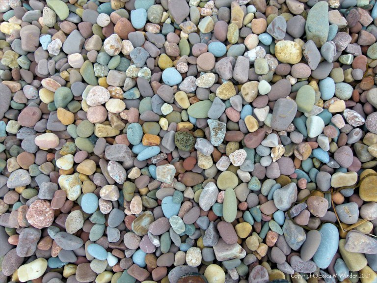 Large pebbles of different rock types on the beach