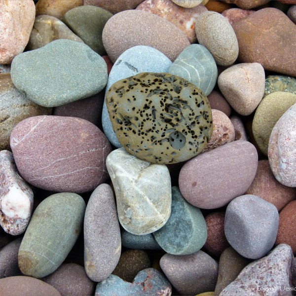 Large pebbles of different rock types on the beach