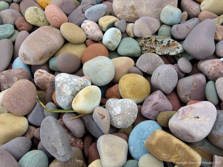 Large pebbles of different rock types on the beach