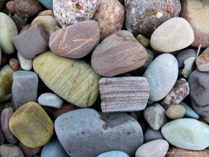 Large pebbles of different rock types on the beach
