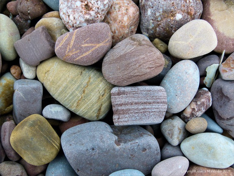 Large pebbles of different rock types on the beach