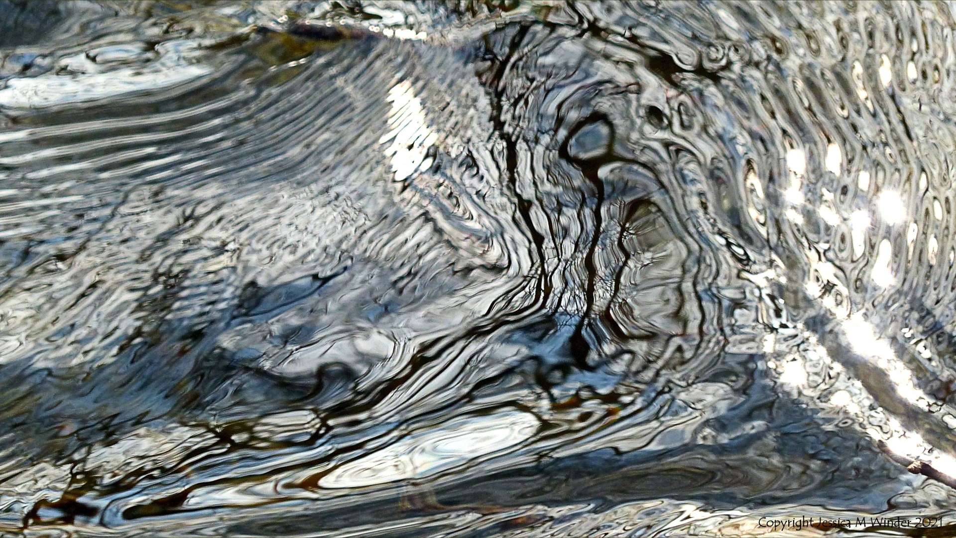 Intricate changing patterns of reflected light on fast flowing water