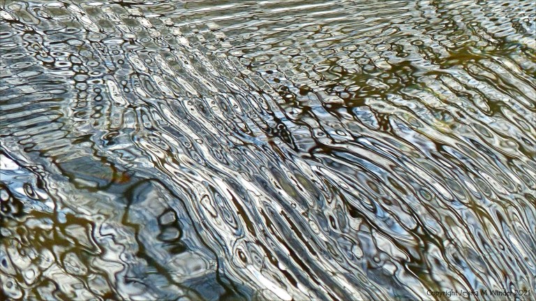 Intricate changing patterns of reflected light on fast flowing water