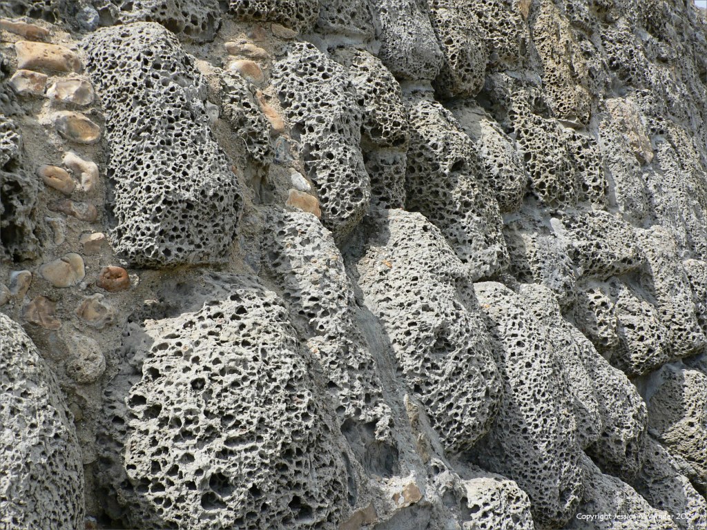 Rocks with holes caused by natural erosion in a sea wall
