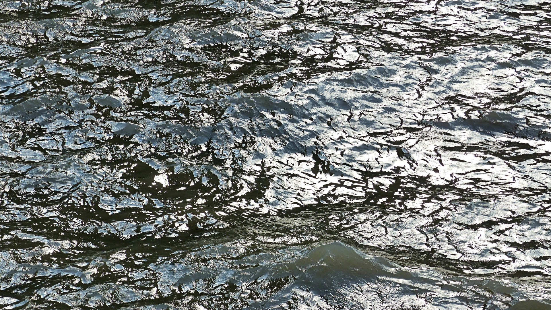 Natural abstract patterns of light reflected on flowing water