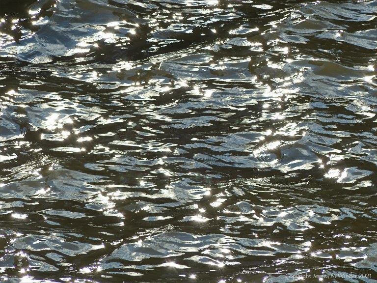 Abstract patterns of light reflected on the surface of flowing water