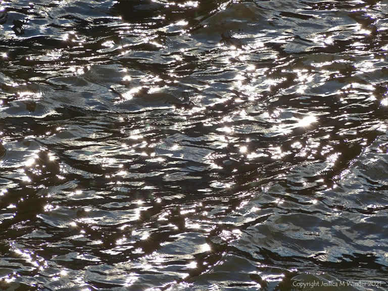 Abstract patterns of light reflected on the surface of flowing water