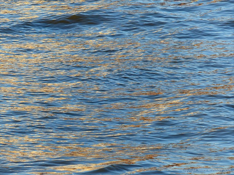 Golden reflected light on water in deep flowing river