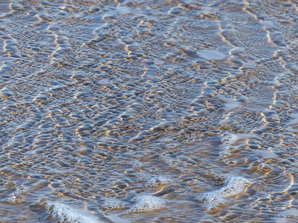 Natural surface texture and pattern of shallow waves breaking on a sandy beach