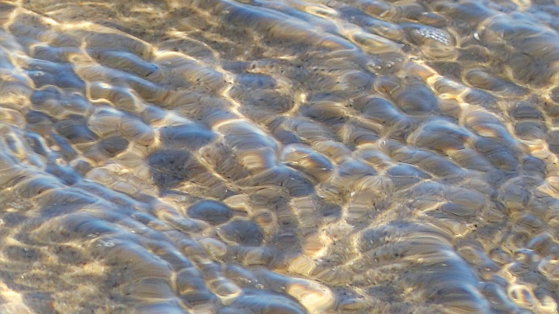 Natural surface texture and pattern of shallow waves breaking on a sandy beach